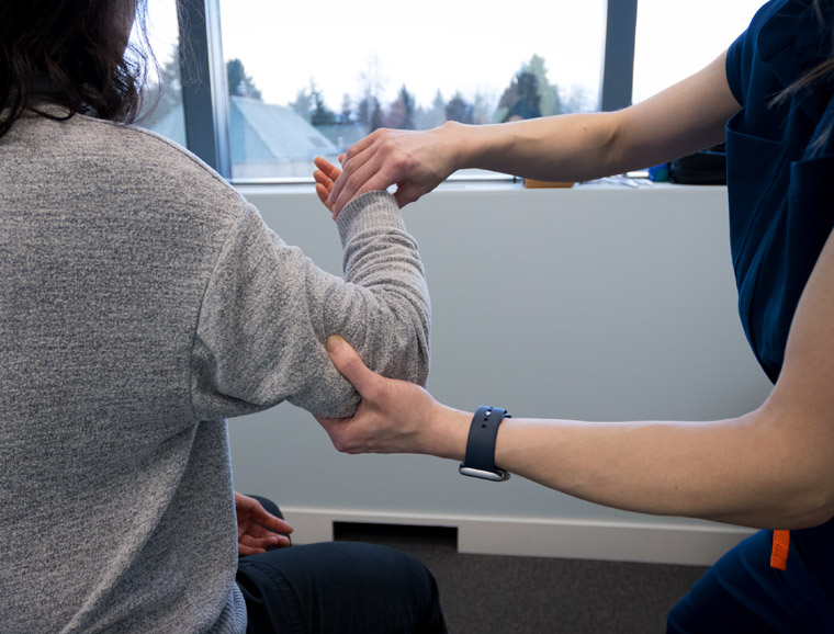 Dr. Kelsey is working on a client's elbow pain.